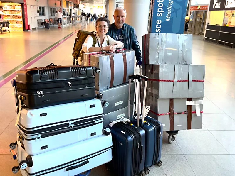 Inna and Alexander Adamovich with medical supply packages at an airport.